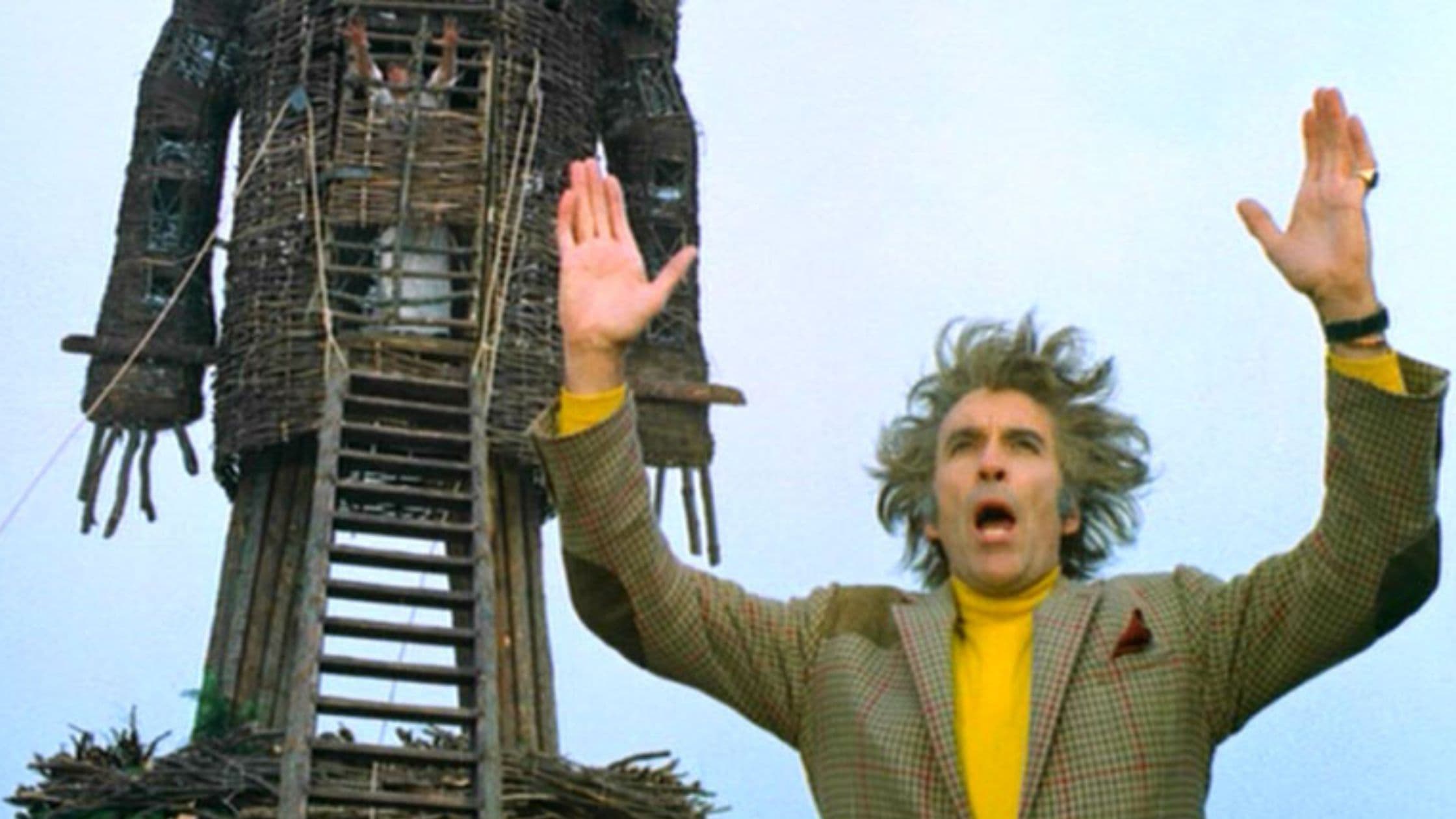 Man in plaid suit raising arms to sky